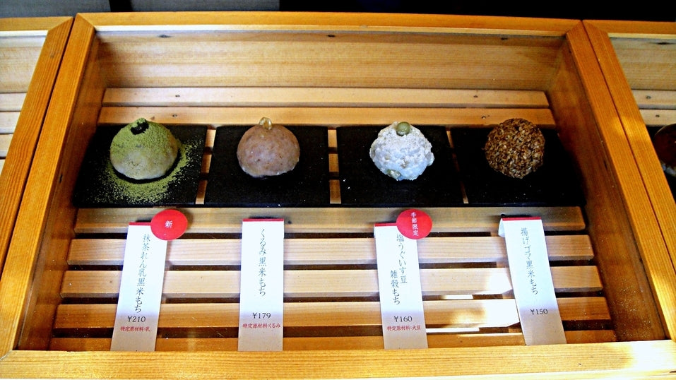 木箱に一つずつ並んだ小ぶりのおはぎ。抹茶、黒ごま、白ごま、きなこ